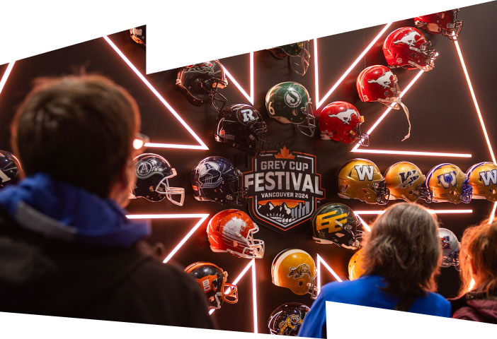 Festival attendees gaze upon a display of LED. lights and CFL. helmets for the 2024 Grey Cup Festival.