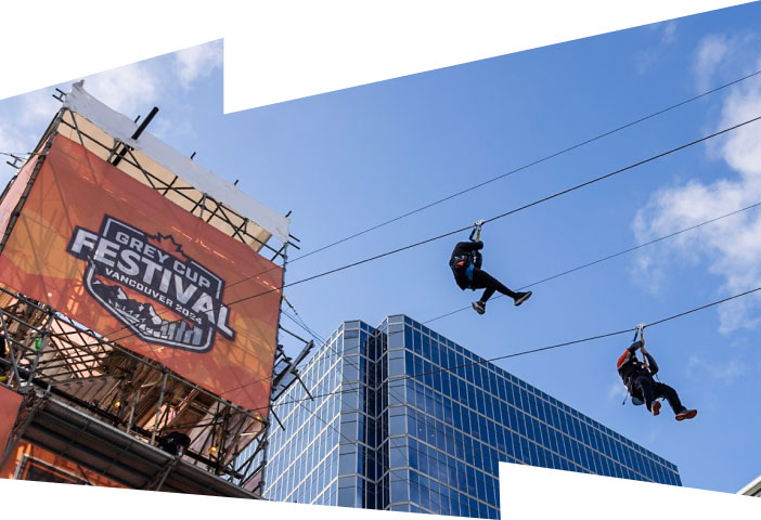 Two attendees zipline across the Vancouver harbour during the 2024 Grey Cup Festival.
