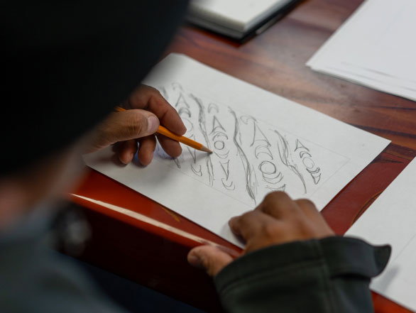 An indigenous artist sketching early design concepts for the Invictus Games 2025 brand.