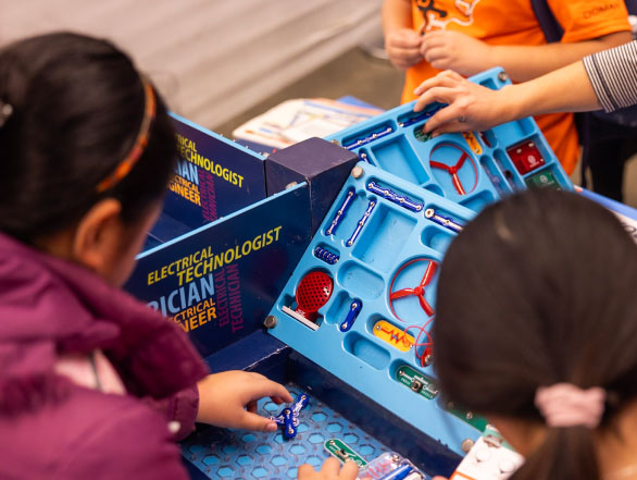 Young children engage with an interactive science exhibit.