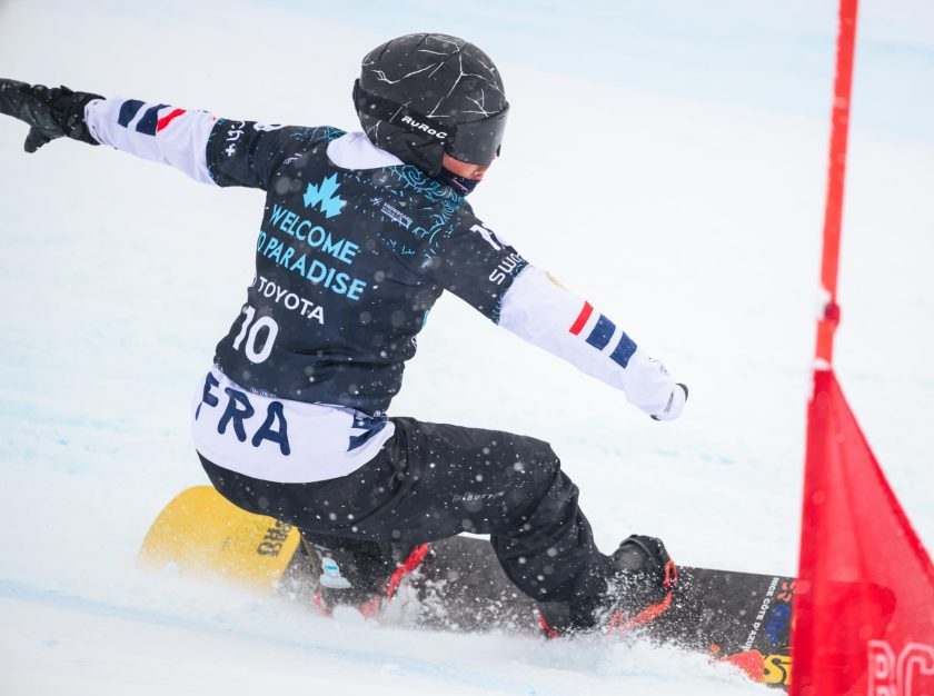 A snowboarder carving around a slalom flag in a FIS Para Snowboard World Championship event – clicking this link will open a larger version of it in the browser window.