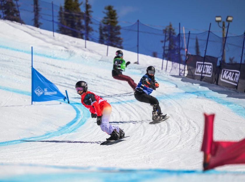 Three competitors racing around a corner at a FIS Para Snowboard World Championship event – clicking this link will open a larger version of it in the browser window.