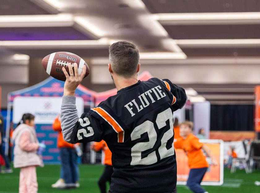 A man in a Doug Flutie jersey prepares to throw a football to a group of children – clicking this link will open a larger version of it in the browser window.